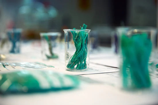 Photo close up of fish net fibres within a small glass pot on a table